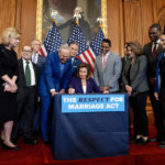 House Speaker Nancy Pelosi of Calif., accompanied by Senate Majority Leader Sen. Chuck Schumer of N.Y., left, and other members of Congress, signs the H.R. 8404, the Respect For Marriage Act, on Capitol Hill in Washington, Thursday, Dec. 8, 2022. (AP Photo/Andrew Harnik)