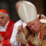 
              FILE - Cardinal Joseph Ratzinger of Germany, left, looks at Pope John Paul II during a Mass in St. Peter's Basilica at the Vatican on Sept. 11, 2002. As John Paul’s right-hand man on doctrinal matters, Ratzinger wrote documents reinforcing church teaching opposing homosexuality, abortion and euthanasia, and asserting that salvation can only be found in the Catholic Church. Pope Emeritus Benedict XVI, the German theologian who will be remembered as the first pope in 600 years to resign, has died, the Vatican announced Saturday Dec. 31, 2022. He was 95. (AP Photo/Pier Paolo Cito, File)
            