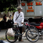 
              A shopper leaves the 17 and K Market on his bike in Havana, Cuba, Friday, Dec. 23, 2022. In October, the Cuban government reported that inflation had risen 40% over the past year and had a significant impact on the purchasing power for many on the island. (AP Photo/Ismael Francisco)
            