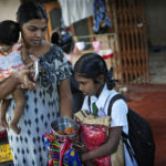 
              Rasarathnam Anushiya gives only two vadei, made from lentils, to her eight years old daughter Madushika in her lunch box before she leaves to school in Vavuniya, about 250 kilometres north east of Colombo, Sri Lanka, Wednesday, Dec. 14, 2022. Due to Sri Lanka's current economic crisis families across the nation have been forced to cut back on food and other vital items because of shortages of money and high inflation. Many families say that they can barely manage one or two meals a day. (AP Photo/Eranga Jayawardena)
            