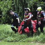 
              Rescuers carry the body of a flood victim that was retrieved from the Jukskei river in Johannesburg, Sunday, Dec. 4, 2022. At least nine people have died while eight others are still missing in South Africa after they were swept away by a flash flood along the Jukskei river in Johannesburg, rescue officials said Sunday. (AP Photo)
            