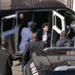 
              FTX founder Sam Bankman-Fried, center, is escorted into the Magistrate Court building from a Corrections Department van, in Nassau, Bahamas, Wednesday, Dec. 21, 2022.(AP Photo/Rebecca Blackwell)
            