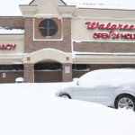 
              A car stranded in snow sits in the parking lot of Walgreens in Buffalo, N.Y.'s Elmwood Village on Monday, Dec. 26, 2022. Clean up is currently under way after a blizzard hit four Western New York counties. (Joseph Cooke/The Buffalo News via AP)
            