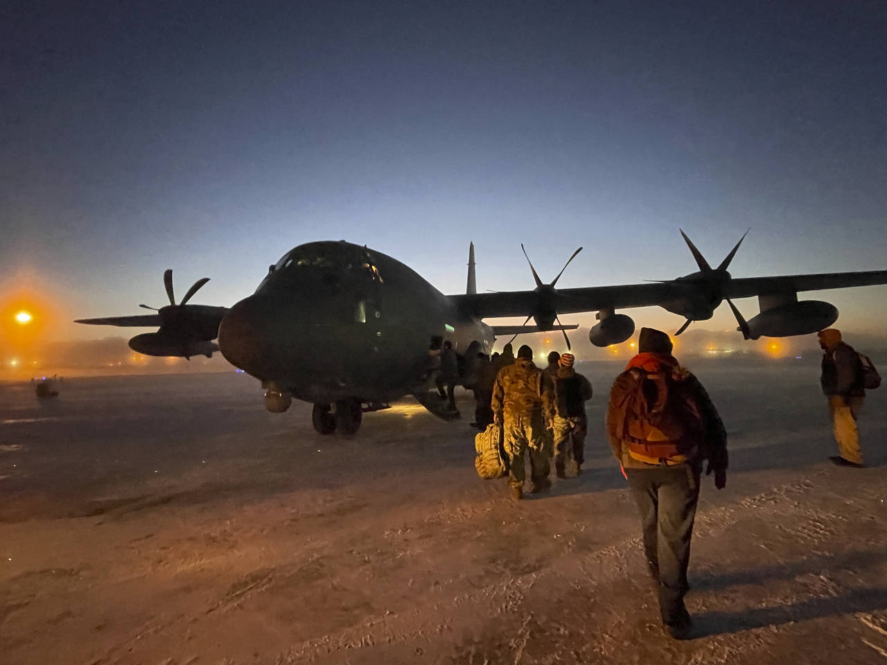 Helpers in the Alaska National Guard's Operation Santa Claus board a cargo plane at Joint Base Elme...