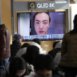 
              A TV screen shows an image of BTS's member Jin with buzz cut, at the Seoul Railway Station in Seoul, South Korea, Monday, Dec. 12, 2022. South Korean media report that Jin is going to enlist the military service on Tuesday. (AP Photo/Ahn Young-joon)
            