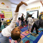 
              First grader Amora Speid, left, stretches out during classes at Chimborazo Elementary School Thursday, Nov. 17, 2022, in Richmond, Va. The Richmond school district, which includes Chimborazo elementary, ultimately decided against year-round school. (AP Photo/Steve Helber)
            