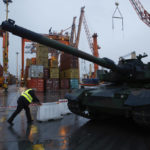 
              A harbour worker pushes a barrier next to the South Korean Black Panther K2 tank in the Polish Navy port of Gdynia, Poland, Tuesday, Dec. 6, 2022. Poland's President Andrzej Duda and the defense minister on Tuesday welcomed the first delivery of tanks and howitzers from South Korea, hailing the swift implementation of a deal signed in the summer in the face of the war in neighbouring Ukraine. (AP Photo/Michal Dyjuk)
            
