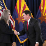 
              Arizona Democrat governor-elect and current Arizona Secretary or State Katie Hobbs, left, shakes hands with Arizona Republican Gov. Doug Ducey, right, after the official certification for the Arizona general election canvass in a ceremony at the Arizona Capitol in Phoenix, Monday, Dec. 5, 2022. (AP Photo/Ross D. Franklin, Pool)
            