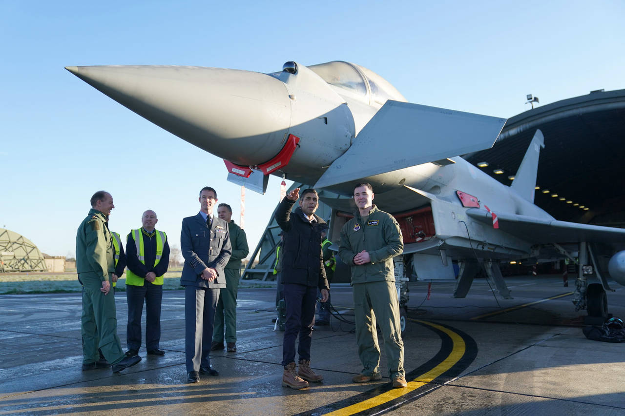 Britain's Prime Minister Rishi Sunak centre, speaks to staff during his visit to RAF Coningsby in L...