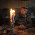 
              Volodymyr Dubrovsliy, a disabled pensioner, lights candles in his house after living without electricity for more than four months in Kupiansk, Kharkiv region, Ukraine, Wednesday, Dec. 28, 2022. (AP Photo/Evgeniy Maloletka)
            