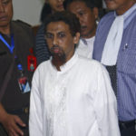 
              File - Indonesian Muslim militant Umar Patek is escorted by prosecutors and plain-clothed police officers as he leaves the courtroom after his hearing at West Jakarta district court in Jakarta, Indonesia, Monday, May 21, 2012. A bombmaker in the 2002 Bali attack that killed 202 people has walked free from an Indonesian prison Wednesday, Dec. 7, 2022 after serving half of a 20-year sentence, despite upsetting Australia’s leader who described him as “abhorrent.” Umar Patek, 55, whose real name is Hisyam bin Alizein, was a leading member of the al Qaida-linked network Jemaah Islamiyah. (AP Photo/Tatan Syuflana, File)
            