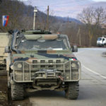 Italian KFOR soldiers, part of the NATO peacekeeping force, park in front of the barricade near the village of Rudare, near the northern, Serb-dominated part of ethnically divided town of Mitrovica, Kosovo, Thursday, Dec. 29, 2022. Serbia's President Aleksandar Vucic says Serbs will start removing their barricades in Kosovo on Thursday in a move that deescalates tensions that triggered fears of new clashes in the Balkans. (AP Photo/Visar Kryeziu)