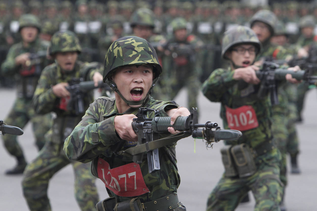 FILE - New recruits practice thrusting with their bayonets at a military training center in Hsinchu...