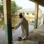 
              Musa Saleh, a 50-year-old Islamic teacher, points at the level the water reached in the early days of floods at Tabawa Primary School northeastern Nigeria, Wednesday Oct. 26, 2022. The flooding that began in June has become the deadliest in more than a decade, according to authorities of this West African nation. More than 600 have been killed. Thousands of homes are destroyed, along with farmland. More than 1.3 million people have been displaced. Lives and livelihoods are upended. (AP Photo/Sunday Alamba)
            