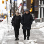 
              Pedestrians make their way along Ottawa's Elgin Street amid high winds, as a winter storm warning is in effect, on Friday, Dec. 23, 2022. (Justin Tang /The Canadian Press via AP)
            