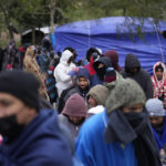 
              FILE - Migrants from Venezuela line up in the cold weather for hot drinks and food from volunteers at a makeshift camp on the U.S.-Mexico Border in Matamoros, Mexico, Friday, Dec. 23, 2022. In a ruling Tuesday, Dec. 27, the U.S. Supreme Court has decided to keep pandemic-era limits on immigration in place indefinitely, dashing hopes of immigration advocates who had been anticipating their end this week. (AP Photo/Fernando Llano, File)
            