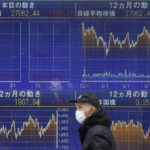 
              A person walks past an electronic stock board showing Japan's Nikkei 225 index, top left, at a securities firm Tuesday, Dec. 13, 2022, in Tokyo. Asian shares are mostly higher as the Federal Reserve and other central banks prepare for the year’s final barrage of interest rate hikes. (AP Photo/Shuji Kajiyama)
            