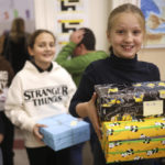 
              Bosnian children carry holiday presents for Ukrainian children at Safvet Beg Basagic elementary school in Sarajevo, Bosnia, Tuesday, Dec. 20, 2022. In homes and schools around Bosnia, youngsters have been preparing gift boxes they hope will put a smile on the faces of their peers living through war in Ukraine. For parents and educators helping the kids select what to send, the experience has awakened a rare found memory of the time when they were on the receiving end of the kindness of strangers while growing up and living in constant fear of death. (AP Photo/Armin Durgut)
            