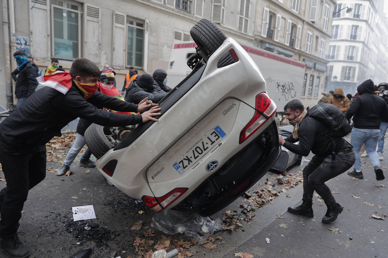 Demonstrators turn a car over during a protest against the recent shooting at the Kurdish culture c...