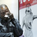 
              Peter Lyoya wipes his eyes after looking at video of his son's shooting during a news conference, Wednesday, Dec. 7, 2022, in Detroit. The family of Patrick Lyoya, a Black motorist fatally shot by a white police officer in Grand Rapids, Mich., filed a lawsuit Wednesday in federal court against the now-former officer and the city of Grand Rapids. The civil rights suit on behalf of Lyoya's family alleges unnecessary, illegal and excessive force and gross negligence by then-Officer Christopher Schurr. (AP Photo/Carlos Osorio)
            