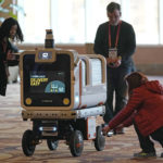 
              Members of the media photograph the Ottobot Yeti as it operates before the start of the CES tech show, Wednesday, Jan. 4, 2023, in Las Vegas. Ottonoy.IO launches Ottobot Yeti at CES 2023. Ottobot Yeti, is a fully autonomous delivery robot that can navigate unattended deliveries for food and beverage retail and curbside deliveries. (AP Photo/Rick Bowmer)
            