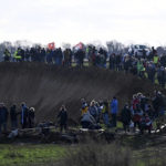 
              Climate protection activists stand on the edge of the open pit mine in Luetzerath, Germany, Sunday, Jan.8, 2023. Luetzerath is to be mined for the expansion of the Garzweiler II opencast lignite mine. (Henning Kaiser/dpa via AP)
            