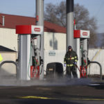 
              A Yakima, Wash., firefighter washes blood off the ground following a fatal shooting at a Circle K convenience store at the intersection of East Nob Hill Boulevard and 18th Street in Yakima, on Tuesday, Jan. 24, 2023. (Emree Weaver/Yakima Herald-Republic via AP)
            