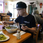 
              Kevin Mok, owner of Mr Obanyaki ice cream shop, near the Star Ballroom Dance Studio, eats noodles at Mandarin Noodle House on Tuesday, Jan. 24, 2023, in Monterey Park, Calif. A gunman killed multiple people at the ballroom dance studio late Saturday amid Lunar New Years celebrations in the predominantly Asian American community. (AP Photo/Ashley Landis)
            