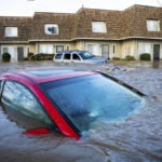 
              Floodwaters course through a neighborhood in Merced, Calif., on Tuesday, Jan. 10, 2023. Following days of rain, Bear Creek overflowed its banks leaving dozens of homes and vehicles surrounded by floodwaters. (AP Photo/Noah Berger)
            