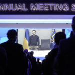 
              President Volodymyr Zelenskyy of Ukraine is seen on a video screen, holding a minute of silence with participants at the World Economic Forum in Davos, Switzerland, for the victims of a helicopter crash in Ukraine, where Minister of Internal Affairs Denys Monastyrsky died among others on Wednesday, Jan. 18, 2023. The annual meeting of the World Economic Forum is taking place in Davos from Jan. 16 until Jan. 20, 2023. (AP Photo/Markus Schreiber)
            