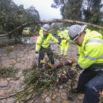 
              Firefighters clear away a fallen tree in Montecito, Calif., Tuesday, Jan. 10, 2023.  California saw little relief from drenching rains Tuesday as the latest in a relentless string of storms swamped roads, turned rivers into gushing flood zones and forced thousands of people to flee from towns with histories of deadly mudslides.  (AP Photo/Ringo H.W. Chiu)
            