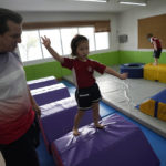 
              Rylae-Ann Poulin attends physical education class at Ruamrudee International School in Bangkok, Thailand, Friday, Jan. 13, 2023. Rylae-Ann was among the first to benefit from a new way of delivering gene therapy _ directly into the brain _ that experts believe holds great promise for treating a host of brain disorders. (AP Photo/Sakchai Lalit)
            