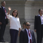 
              Surrounded by security, Peruvian President Dina Boluarte waves to the press outside the government palace as Prime Minister Alberto Otarola departs in Lima, Peru, Tuesday, Jan. 10, 2023. (AP Photo/Martin Mejia)
            