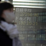 
              A person wearing a protective mask walks in front of an electronic stock board showing Japan's Nikkei 225 index at a securities firm Wednesday, Jan. 25, 2023, in Tokyo. Asian shares were mixed Wednesday after Wall Street indexes finished little changed as investors awaited earnings results from major global companies. (AP Photo/Eugene Hoshiko)
            