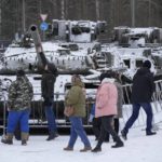 
              People visit an exhibition of tanks and APCs of Ukrainian armed forces damaged and captured during the fighting at an exhibition at the museum "Breakthrough of the Siege of Leningrad" in Kirovsk, about 30 kilometres (19 miles) east of St. Petersburg, Russia, Sunday, Jan. 22, 2023. (AP Photo/Dmitri Lovetsky)
            