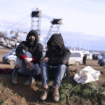 
              Two climate protection activists sit in front of a bucket-wheel excavator on the edge of the lignite village of Luetzerath, , which is expected to be excavated for the expansion of the Garzweiler II opencast lignite mine, in Luetzerath, Erkelenz, Germany, Saturday, Jan.7, 2023. (David Young/dpa via AP)
            