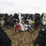 
              Police officers surround climate protesters sitting on the ground at the village Luetzerath near Erkelenz, Germany, Wednesday, Jan. 11, 2023. Police on Wednesday moved into a condemned village in western Germany, launching an effort to evict activists holed up at the site in an effort to prevent its demolition to make way for the expansion of a coal mine.  (Rolf Vennenbernd/dpa via AP)
            