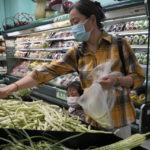 
              FILE - Residents wearing masks shop at a supermarket in the Chaoyang district of Beijing, on April 25, 2022. Food companies making big profits as inflation has surged should face windfall taxes to help cut global inequality, anti-poverty group Oxfam said Monday Jan. 16, 2023 as the World Economic Forum's annual meeting gets underway. (AP Photo/Ng Han Guan, File)
            