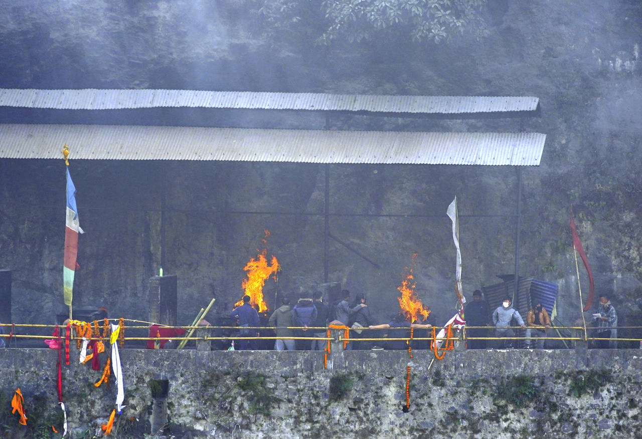 Relatives and friends perform last rites of the plane crash victims, in Pokhara, Nepal, Wednesday, ...