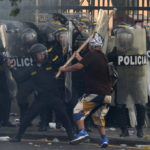 
              An anti-government protesters charges the police with a club during clashes in Lima, Peru, Thursday, Jan. 19, 2023. Peruvians have been protesting since early December, when former President Pedro Castillo was impeached after an  attempt to dissolve Congress. His vice president, Dina Boluarte, replaced him, and has faced strong opposition ever since. (AP Photo/Martin Mejia)
            