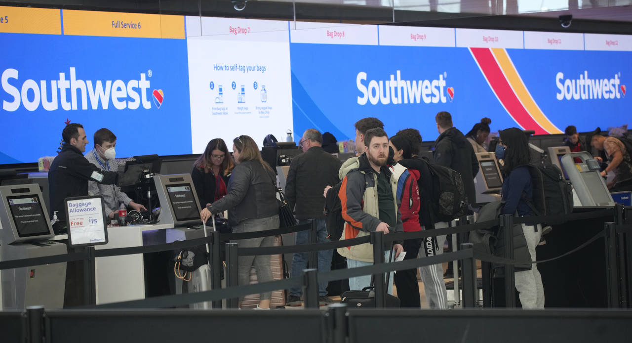 FILE - Travelers queue up at the check-in counters for Southwest Airlines in Denver International A...