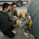 
              Two men place flowers near Star Dance Studio to honor victims killed in a shooting in Monterey Park, Calif., Sunday, Jan. 22, 2023. A gunman killed multiple people at a ballroom dance studio late Saturday amid Lunar New Years celebrations in the predominantly Asian American community of Monterey Park. (AP Photo/Jae C. Hong)
            
