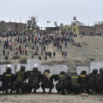 
              Anti-government protesters face off with security outside Alfredo Rodriguez Ballon airport in Arequipa, Peru, Thursday, Jan. 19, 2023. Protesters are seeking immediate elections, President Dina Boluarte's resignation, the release of ousted President Pedro Castillo and justice for up to 48 protesters killed in clashes with police. (AP Photo/Jose Sotomayor)
            