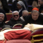
              FILE - Australian Cardinal George Pell stands next to the body of late Pope Benedict XVI lying in state inside St. Peter's Basilica at The Vatican, Tuesday, Jan. 3, 2023. Pell, who was the most senior Catholic cleric to be convicted of child sex abuse before his convictions were later overturned, has died Tuesday, Jan. 10, 2023, in Rome at age 81. (AP Photo/Gregorio Borgia)
            