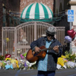 
              Gabriel Alexander plays a guitar and sings near a memorial outside the Star Ballroom Dance Studio on Tuesday, Jan. 24, 2023, in Monterey Park, Calif. A gunman killed multiple people at the ballroom dance studio late Saturday amid Lunar New Years celebrations in the predominantly Asian American community. (AP Photo/Ashley Landis)
            