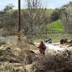 
              In this photo provided by Neil Collins, the SUV belonging to Lindsy Doan sits in floodwaters on Monday, Jan. 9, 2023, in San Miguel, Calif. Doan, along with her son, Kyle Doan, were swept away by rising floodwaters near the San Marcos Creek in San Miguel. The mother was eventually rescued, but her 5-year-old son remains missing.  (Neil Collins via AP)
            