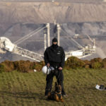 
              A police officer guards the demolition edge of the open pit mine Garzweiler at the village Luetzerath near Erkelenz, Germany, Wednesday, Jan. 11, 2023. Police have entered the condemned village in launching an effort to evict activists holed up at the site in an effort to prevent its demolition to make way for the expansion of a coal mine. (AP Photo/Michael Probst)
            
