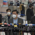 
              Hong Kong Chief Executive John Lee, center, wearing a face mask speaks to the media after he inspected Lok Ma Chau station following the reopening of crossing border with mainland China, in Hong Kong, Sunday, Jan. 8, 2023. Travelers crossing between Hong Kong and mainland China, however, are still required to show a negative COVID-19 test taken within the last 48 hours, a measure China has protested when imposed by other countries. (AP Photo/Bertha Wang)
            