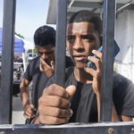 
              Kevin Perez of Matanzas, Cuba, calls his grandmother from a U.S. Customs and Border Protection facility Thursday, Jan. 5, 2023, in Marathon, Fla. Perez arrived a few days ago after nine days at sea. (AP Photo/Marta Lavandier)
            