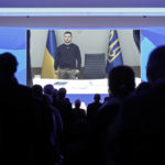 
              President Volodymyr Zelenskyy of Ukraine is seen on a video screen, holding a minute of silence with participants at the World Economic Forum in Davos, Switzerland, for the victims of a helicopter crash in Ukraine, where Minister of Internal Affairs Denys Monastyrsky died among others on Wednesday, Jan. 18, 2023. The annual meeting of the World Economic Forum is taking place in Davos from Jan. 16 until Jan. 20, 2023. (AP Photo/Markus Schreiber)
            